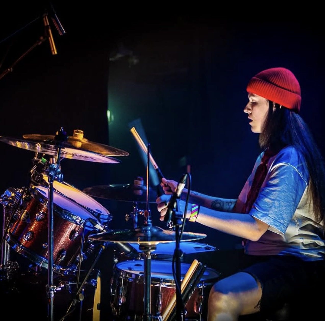ACB in a red beanie under blue light